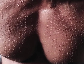 Close up into the sweat over flexing body